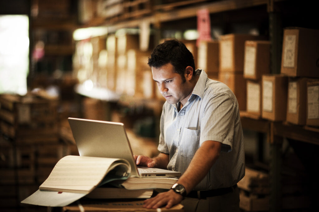 Man looking at inventory on a balance sheet