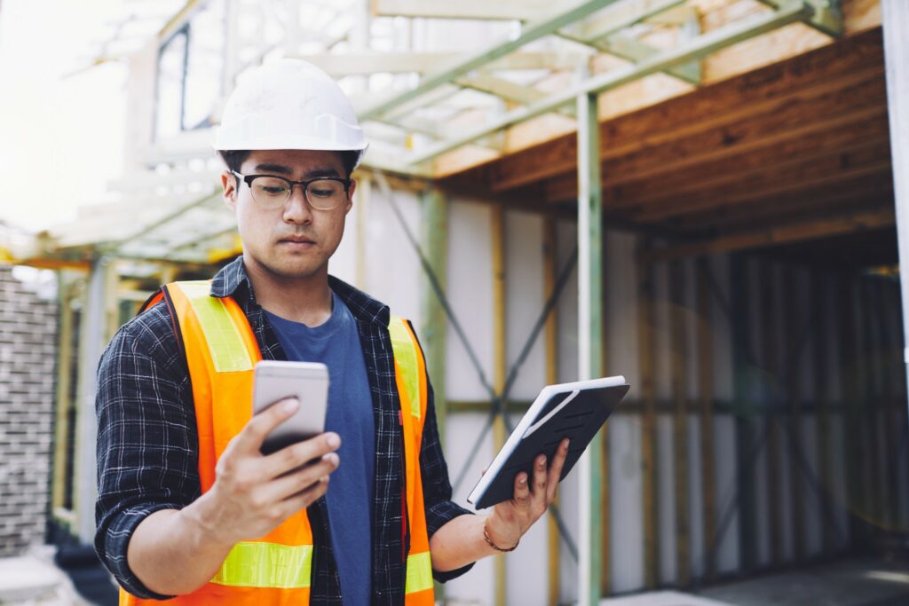 Construction worker takes inventory using wireless devices.