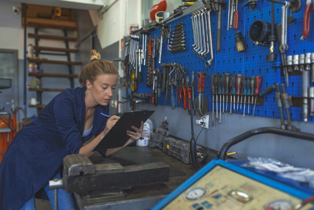 A woman takes inventory in an auto shop.