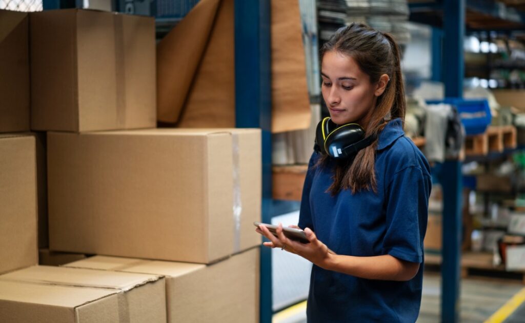A woman manages large quantities of inventory in a warehouse.